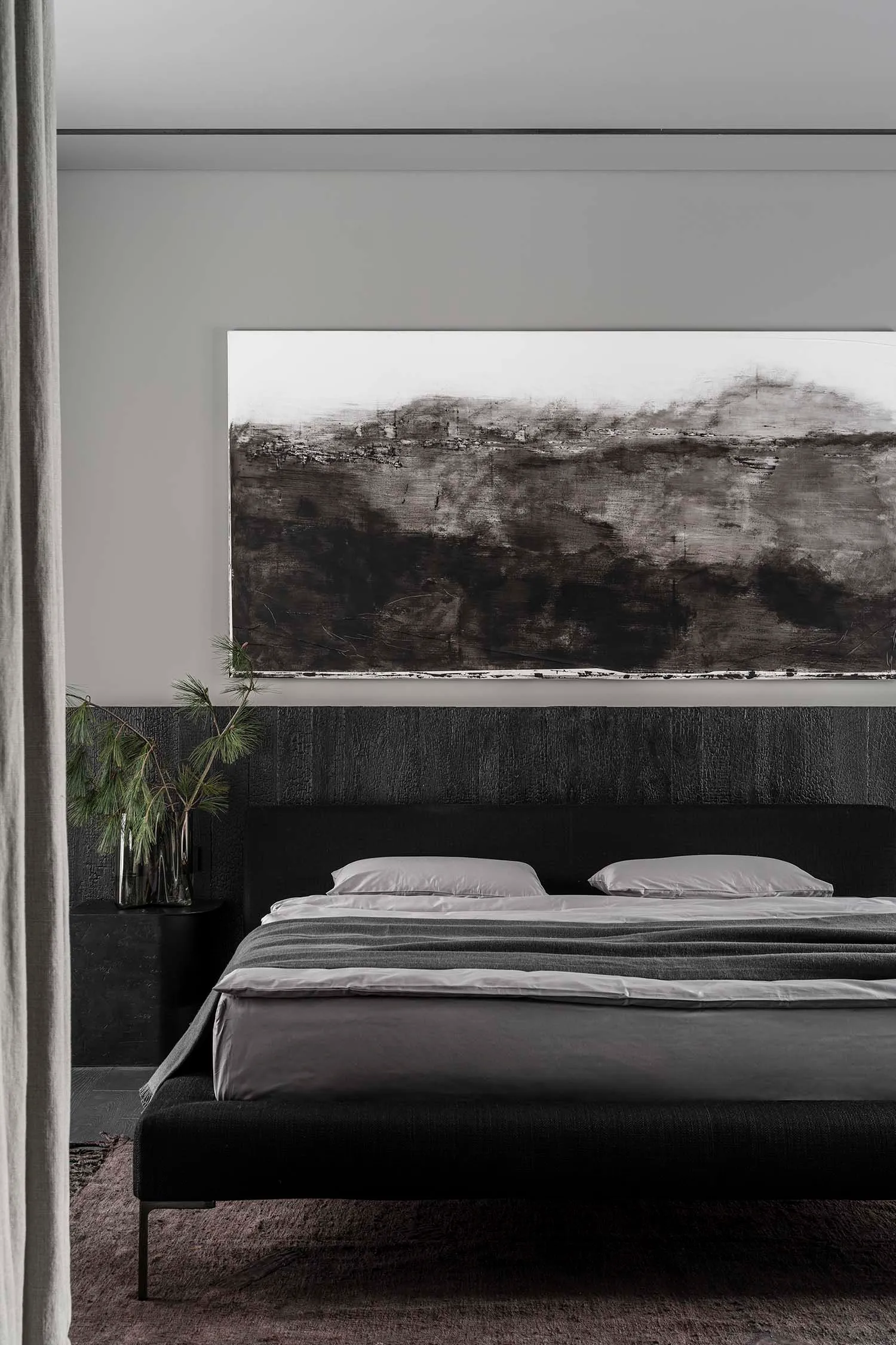 Modern bedroom with black textured walls, minimalist furniture, and abstract black-and-white artwork.