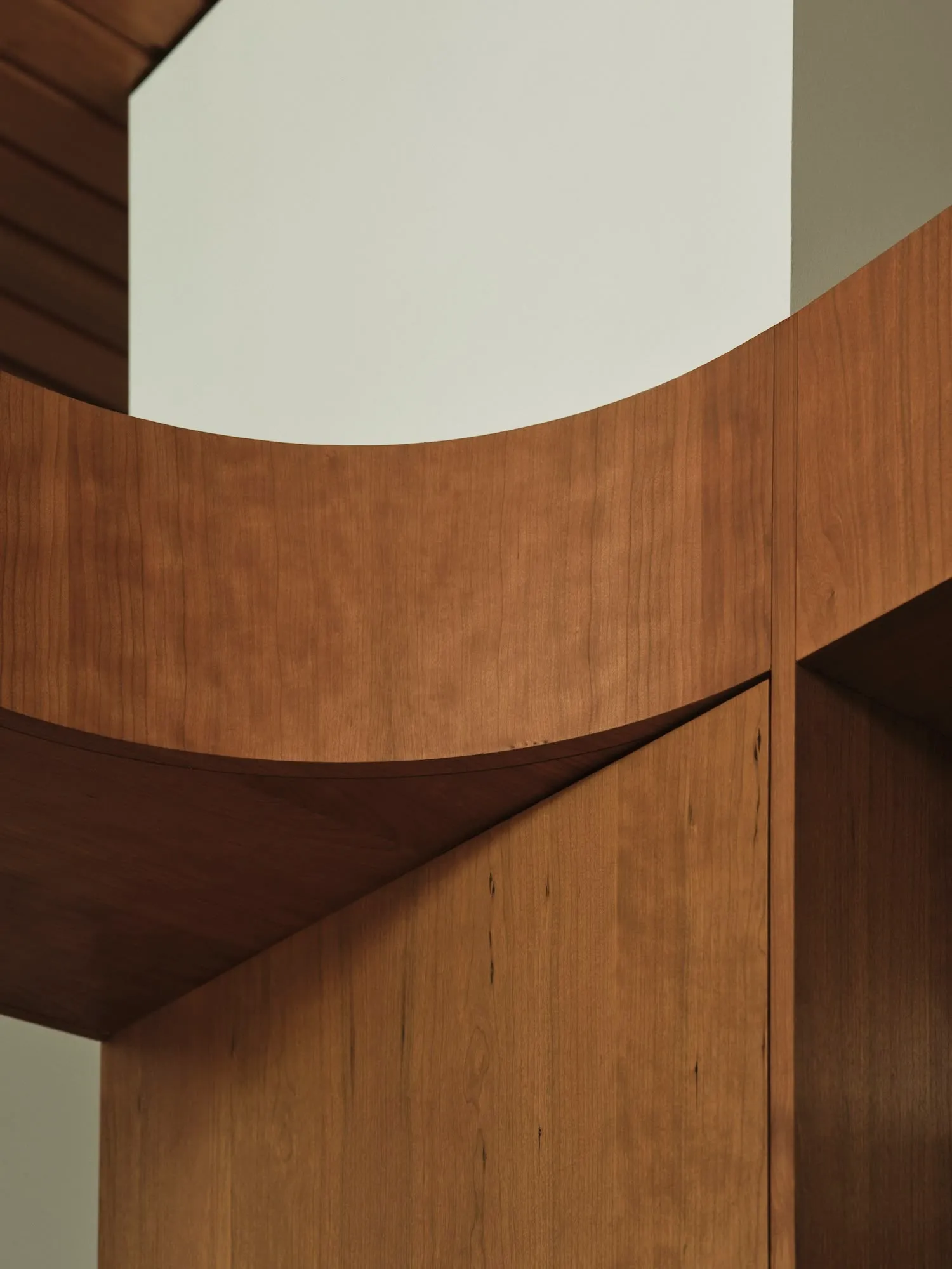 A modern interior design featuring wooden cabinets with curved edges.