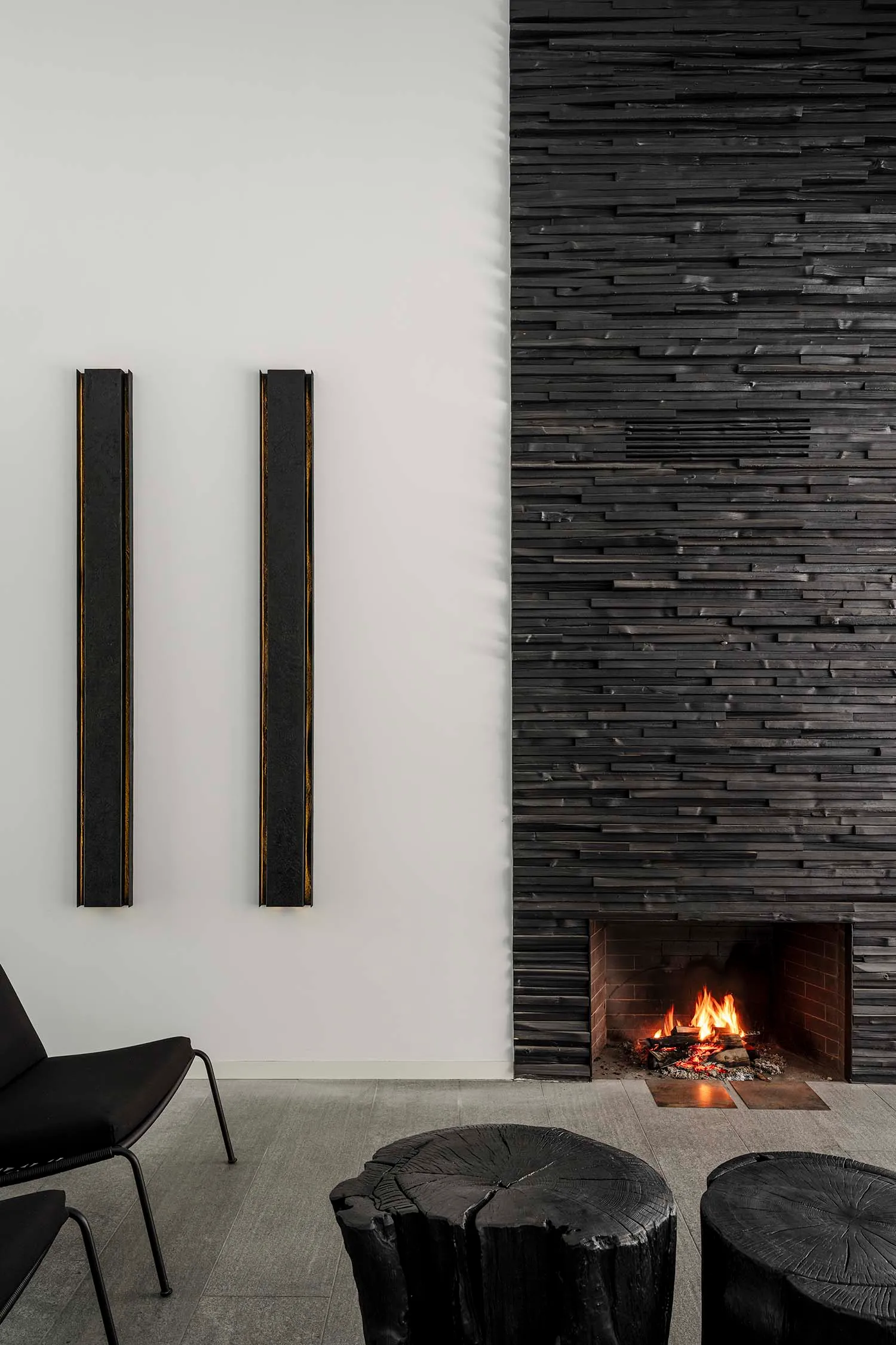 A modern black stone fireplace in a living room setting with seating.