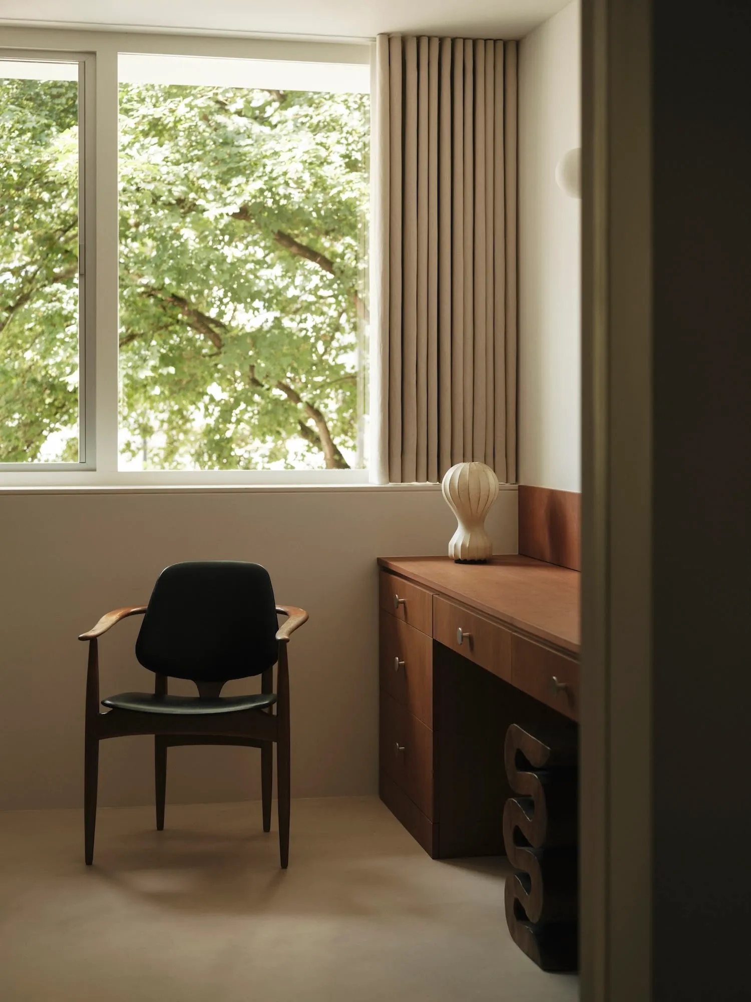 Modern living room featuring wooden furniture, large windows, and a cozy ambiance.