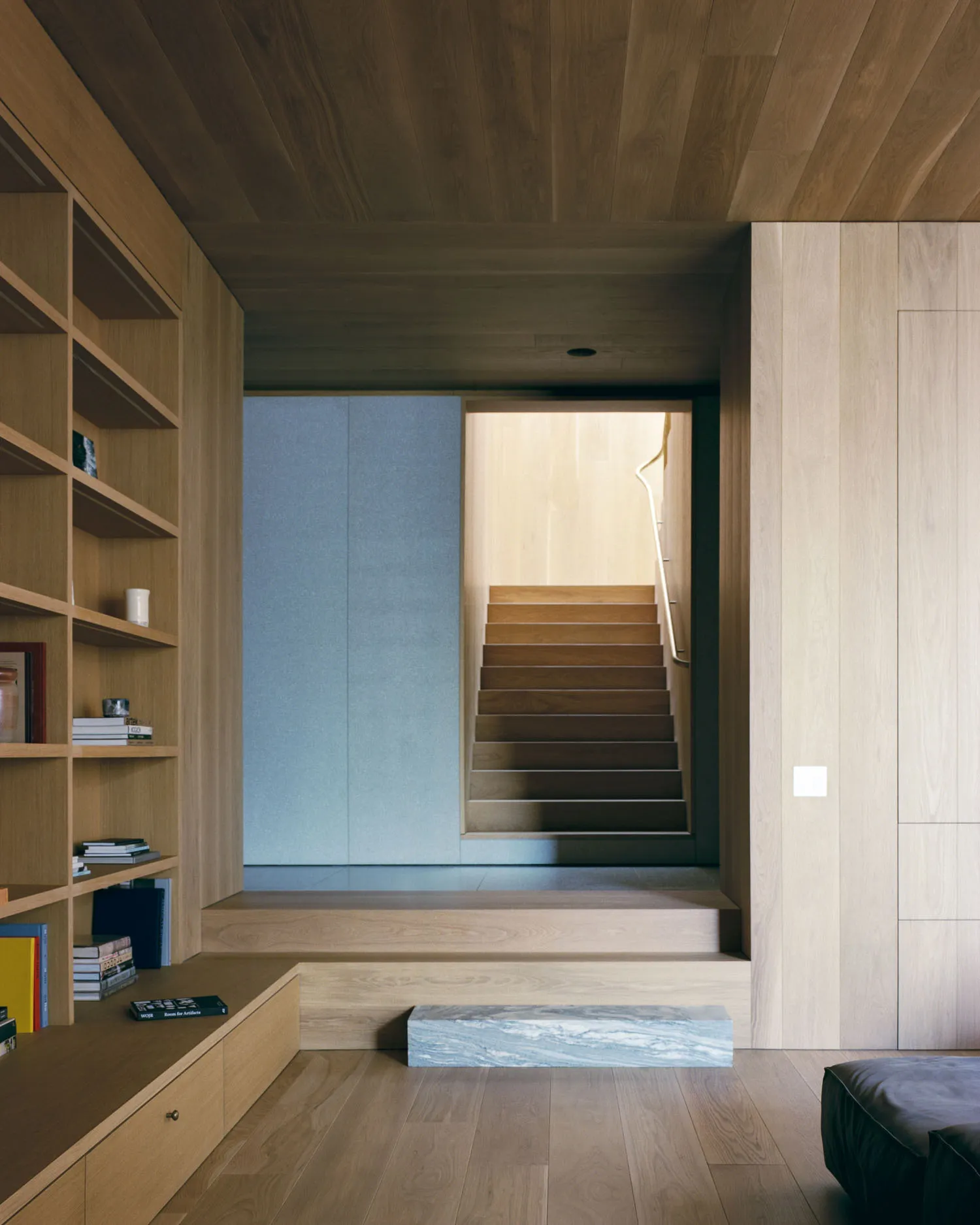 Modern minimalist interior with wooden walls and stairs.