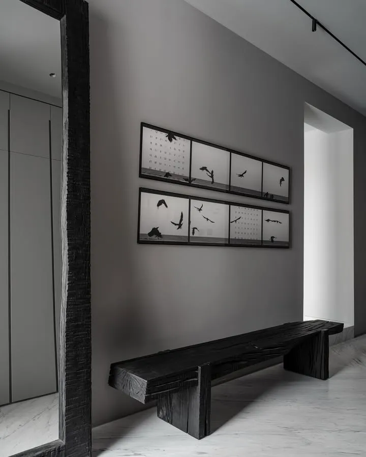 Industrial-style interior design featuring a wooden bench with black and white photography of birds on the wall.