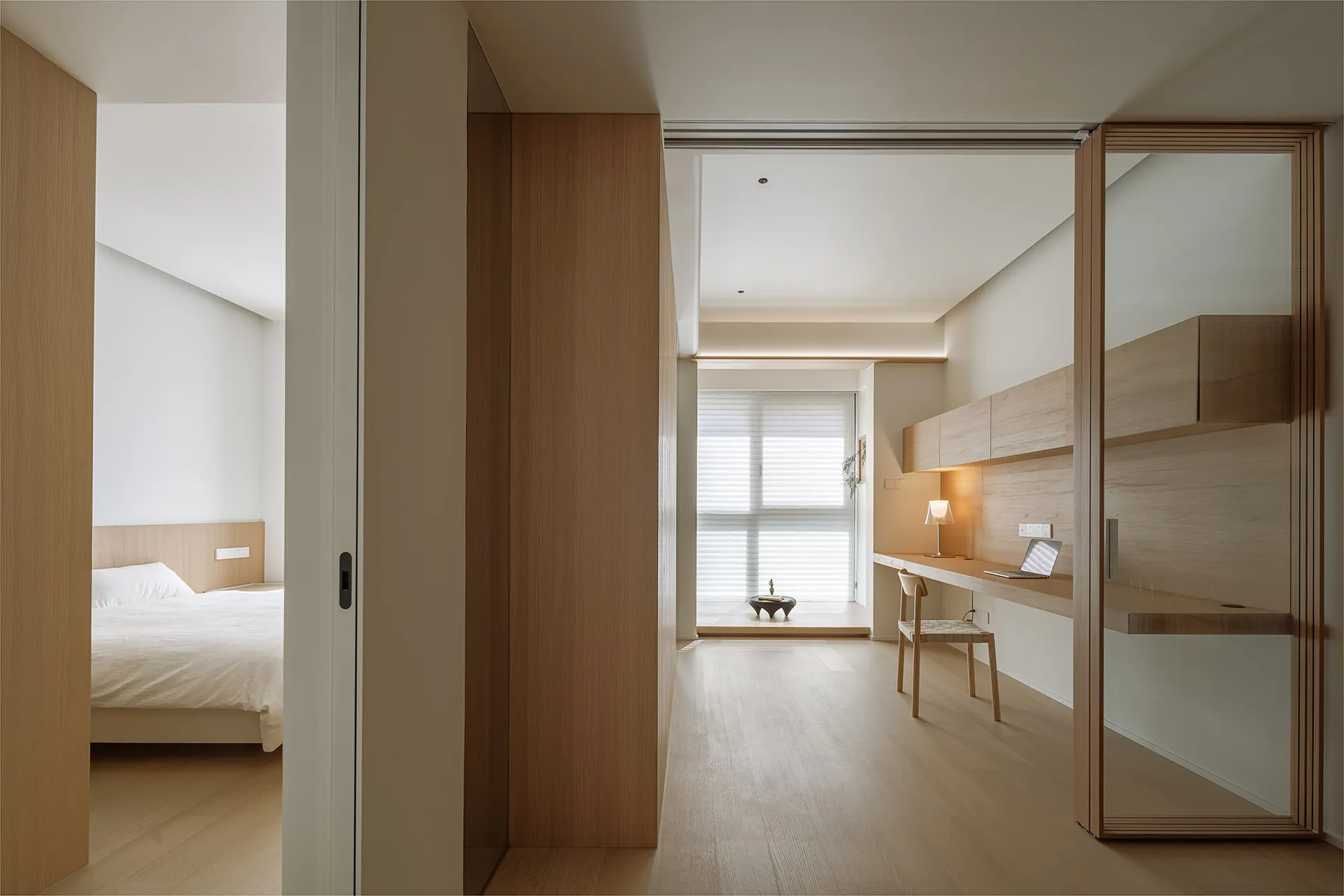 A modern minimalist bedroom featuring wooden elements and a clean, spacious design.