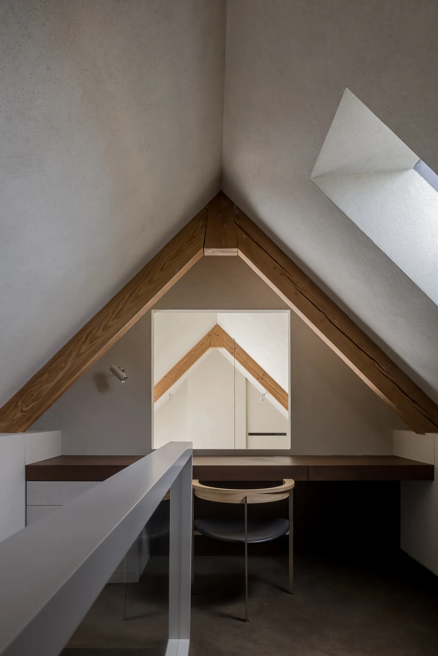 Modern office desk area with wooden elements and a skylight.