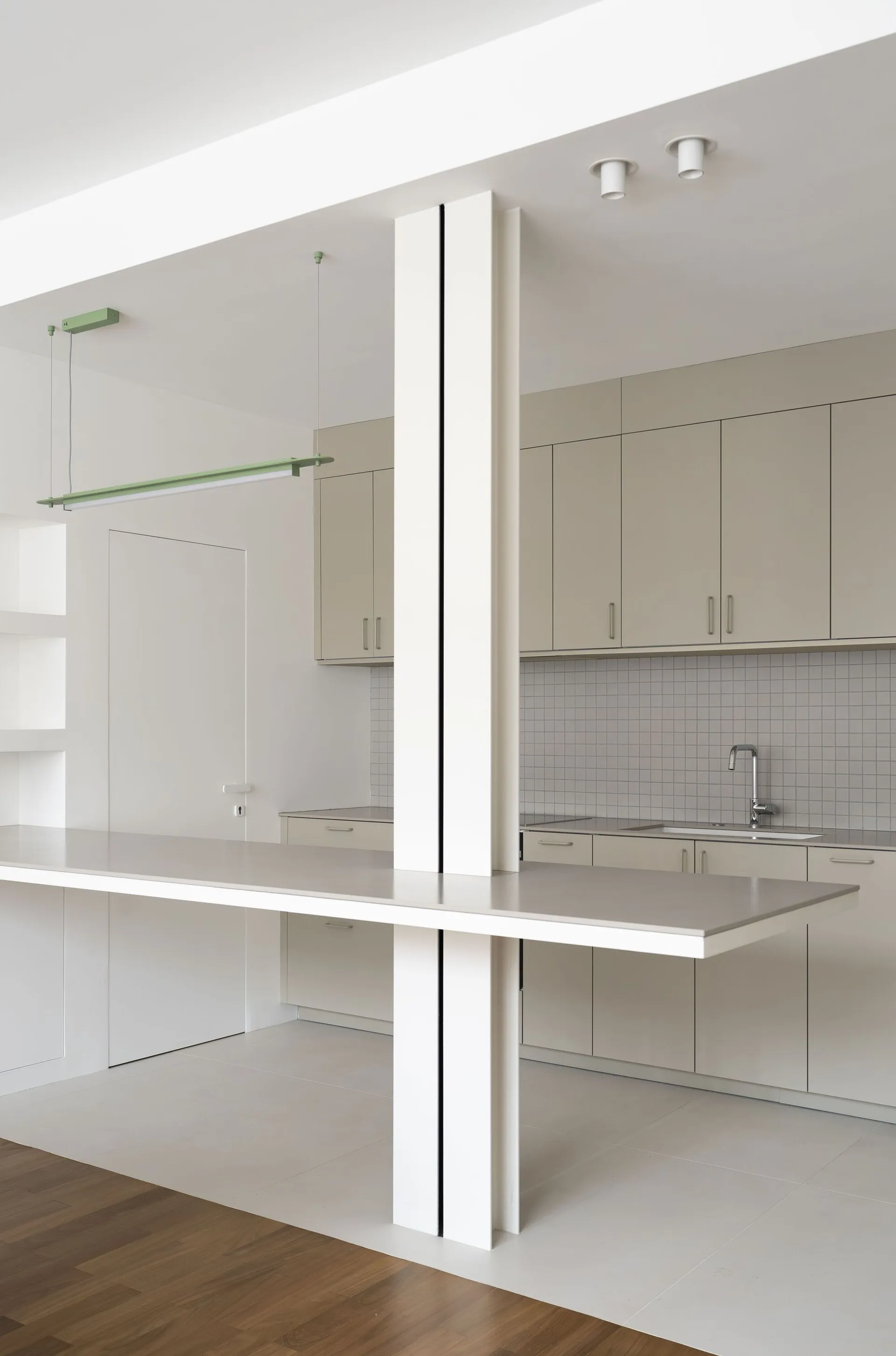 A minimalist white kitchen featuring metallic countertops.