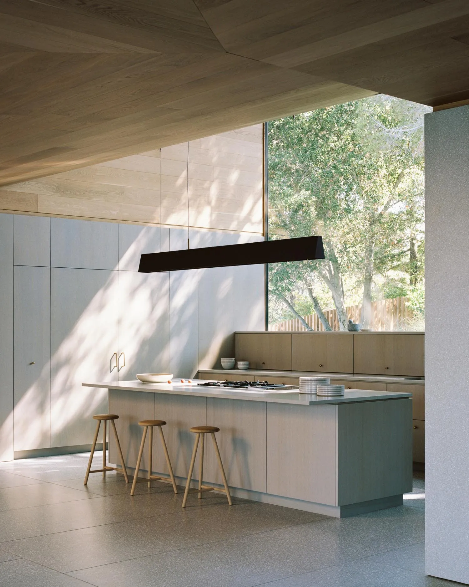 Modern residential kitchen featuring wood cabinets and a large island.