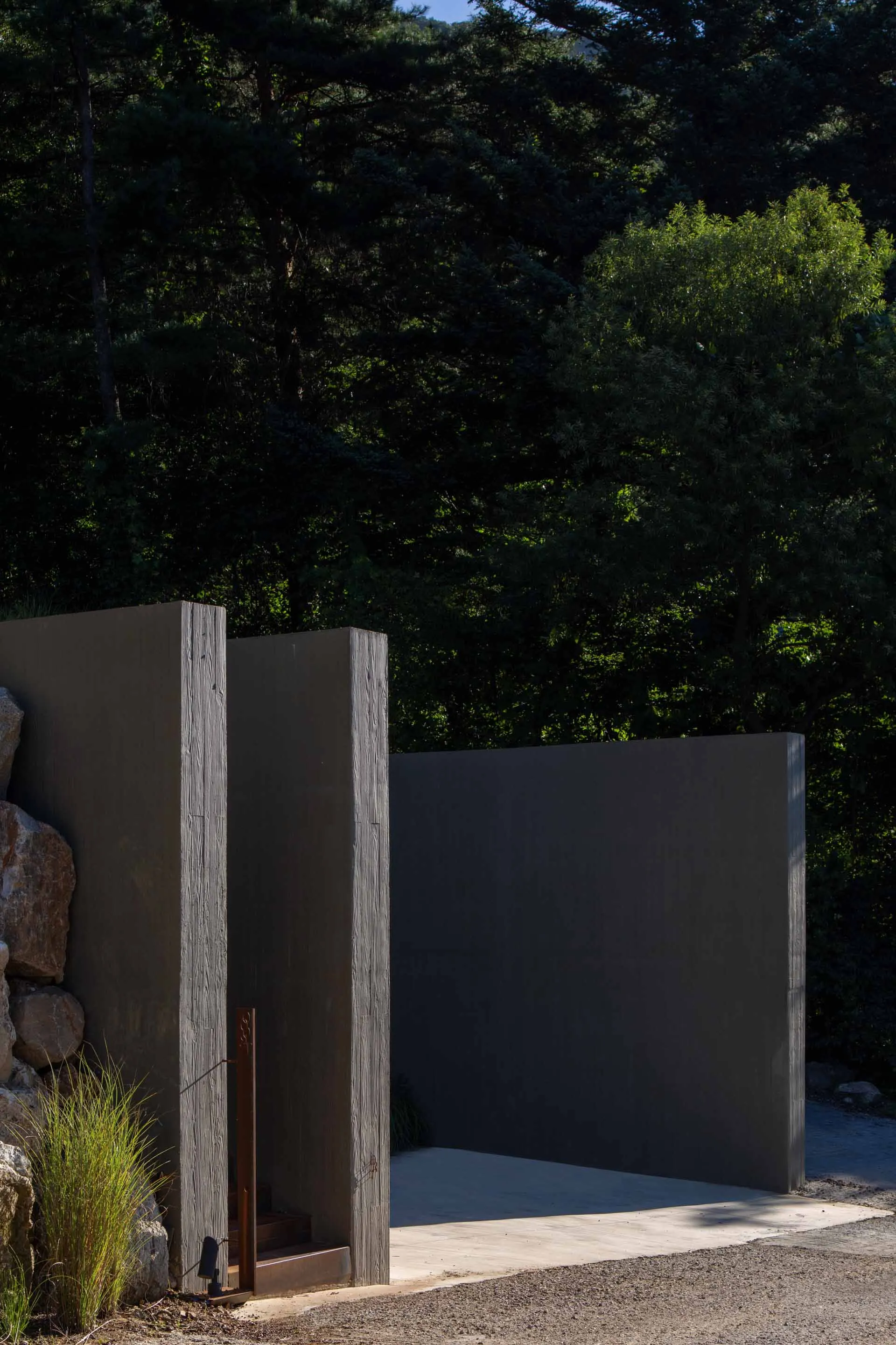Modern architectural entrance featuring metal cladding and concrete materials.