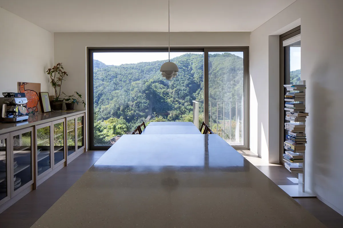 Minimalist modern kitchen with white color scheme and concrete countertops.