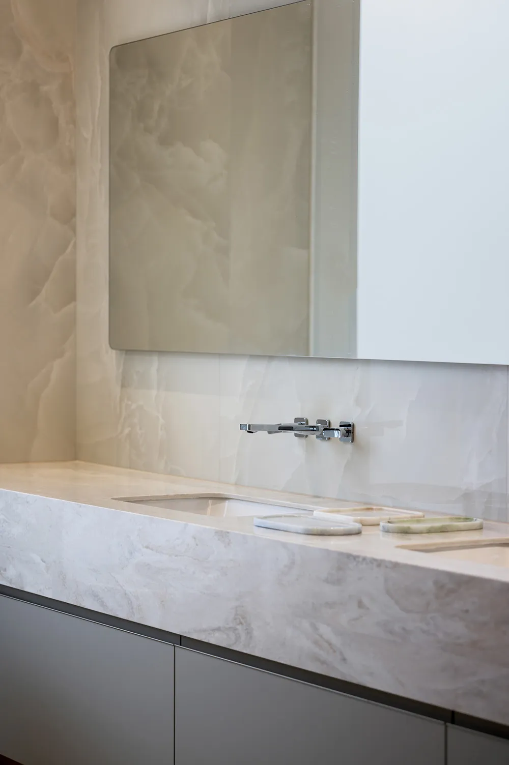 A modern bathroom featuring a marble countertop and sink with a minimalist design.