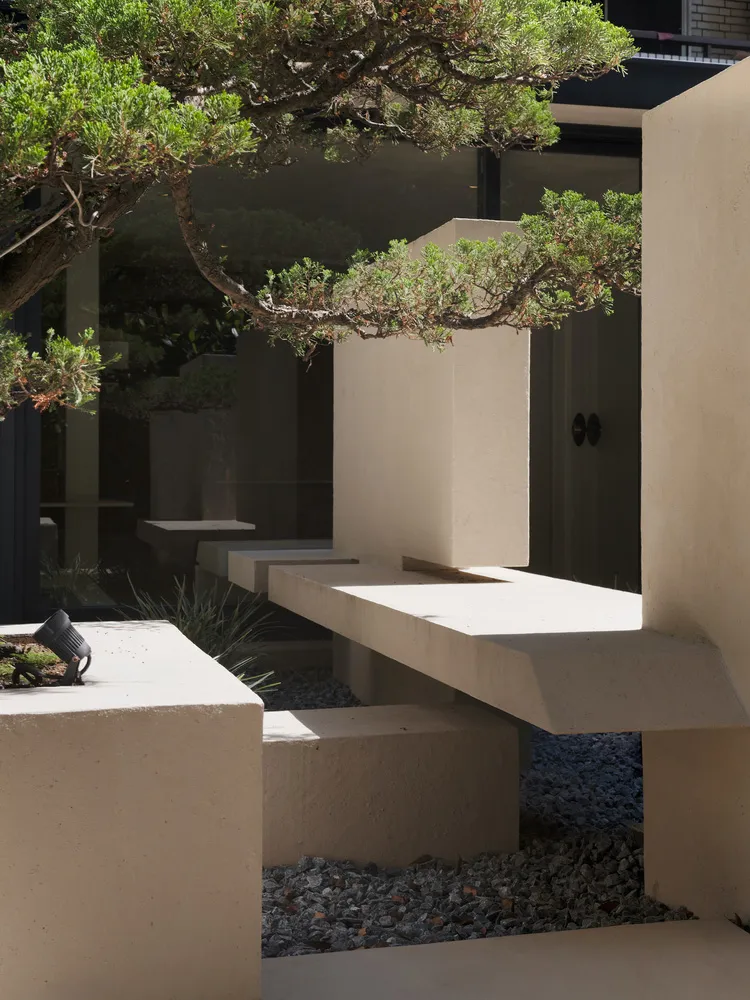 Concrete seating and landscaping elements in a modern architectural entryway.