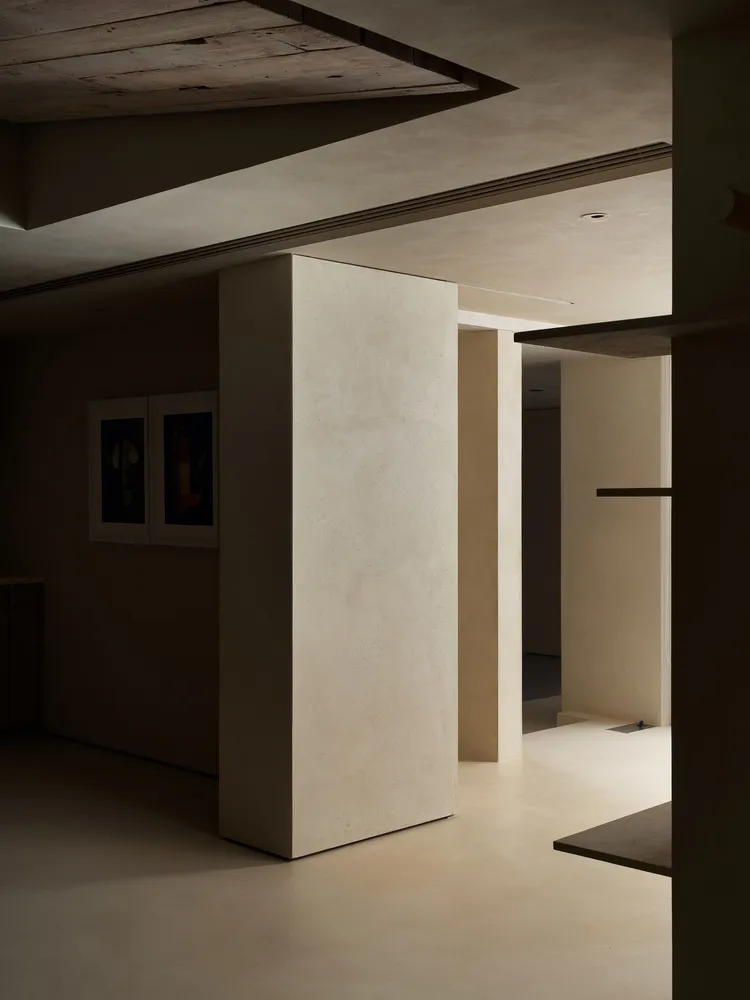 A minimalist interior design featuring concrete walls and flooring, with a focus on clean lines and open spaces.