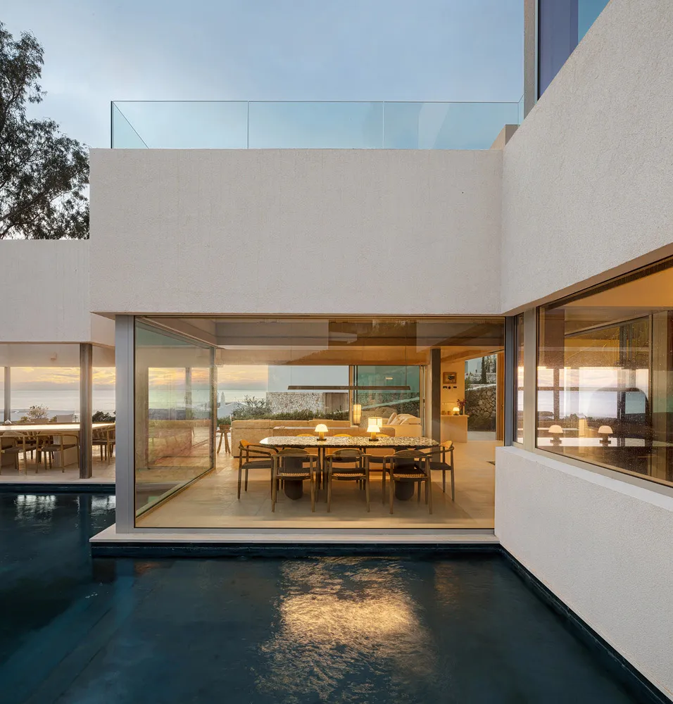 A modern residential space featuring glass walls overlooking a poolside area.