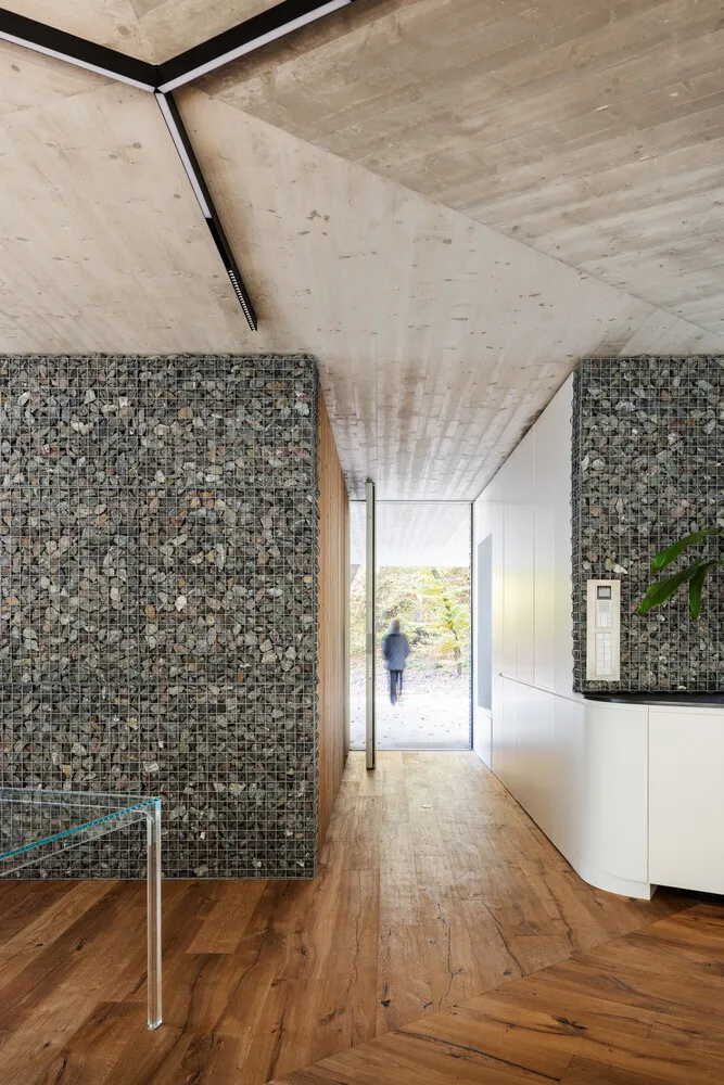 A modern interior featuring concrete walls and wooden flooring.