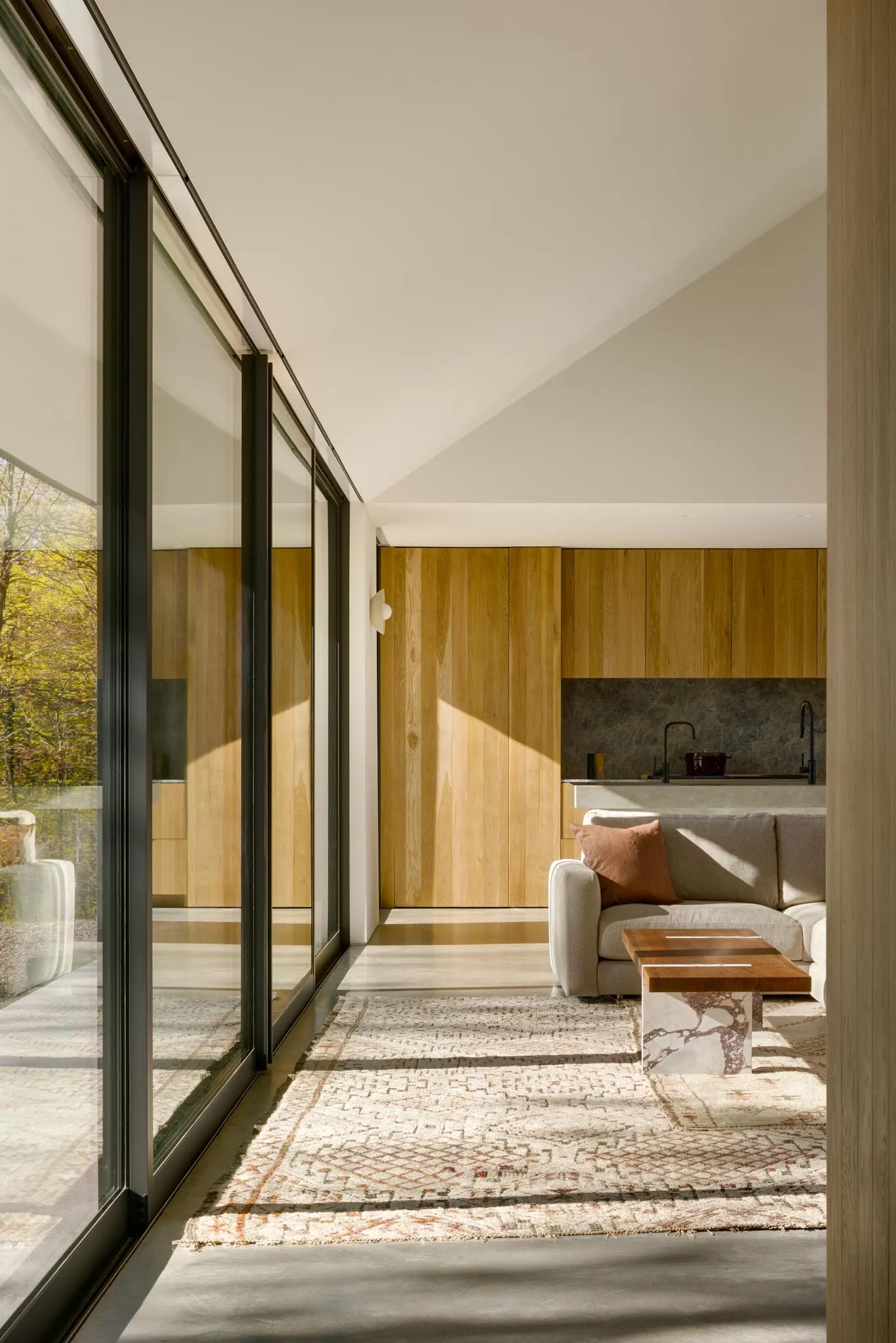 A modern interior with wooden walls, concrete flooring, and glass windows.