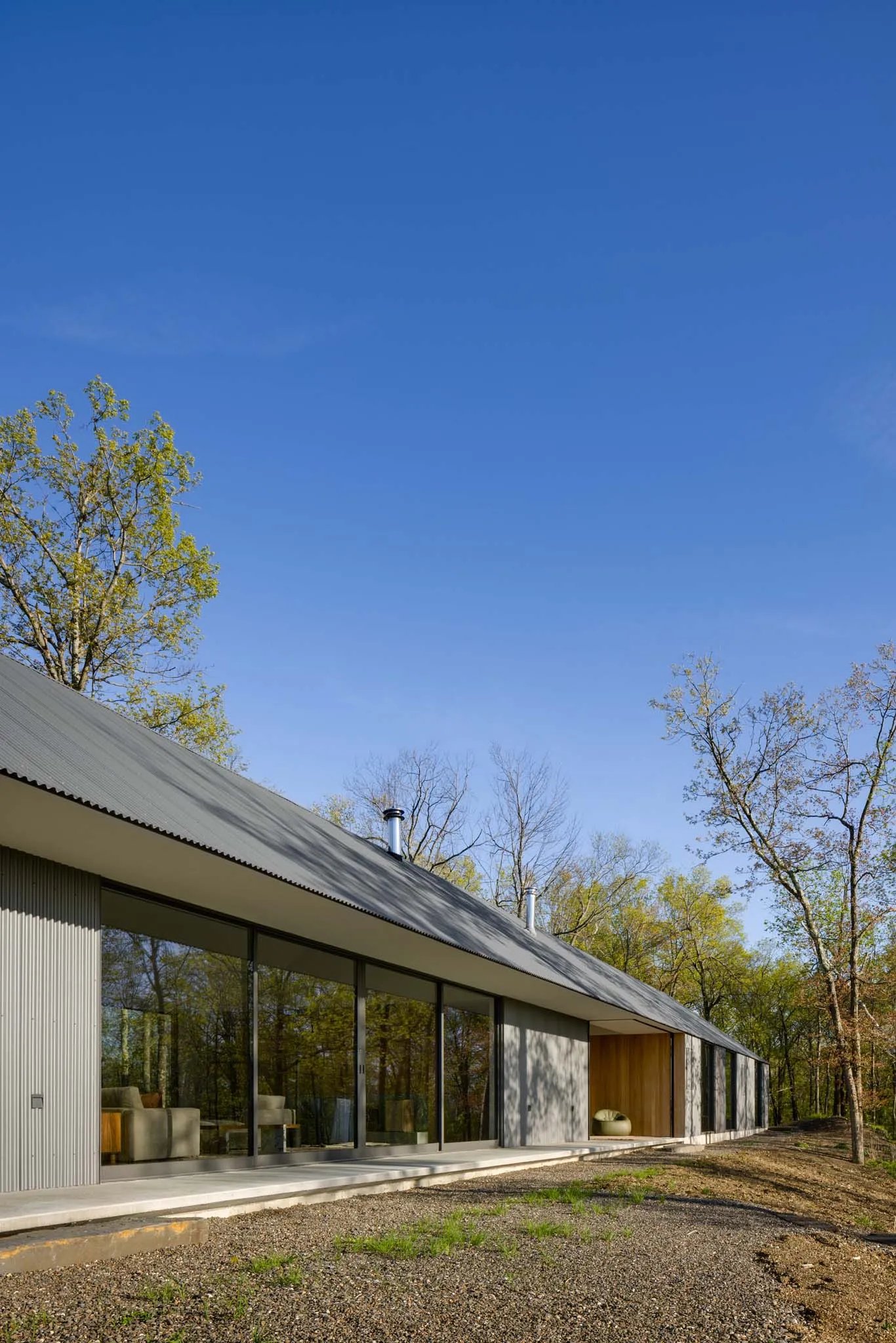 Modern minimalist metal building with large windows and a flat roof.