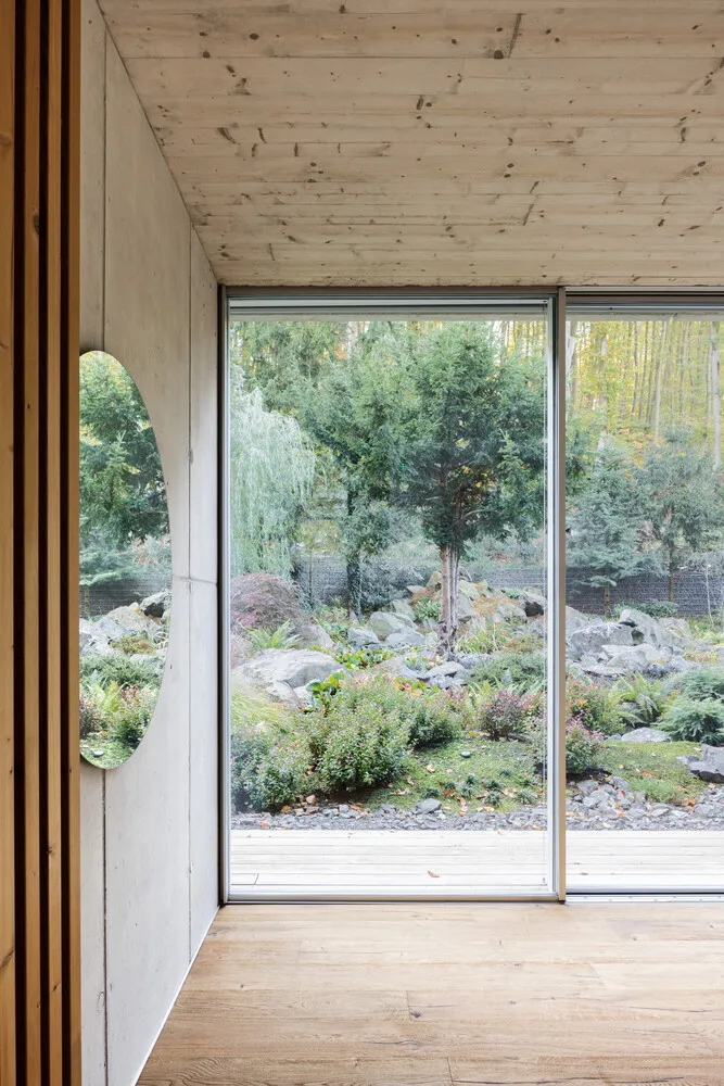 Modern interior featuring a glass window overlooking a garden