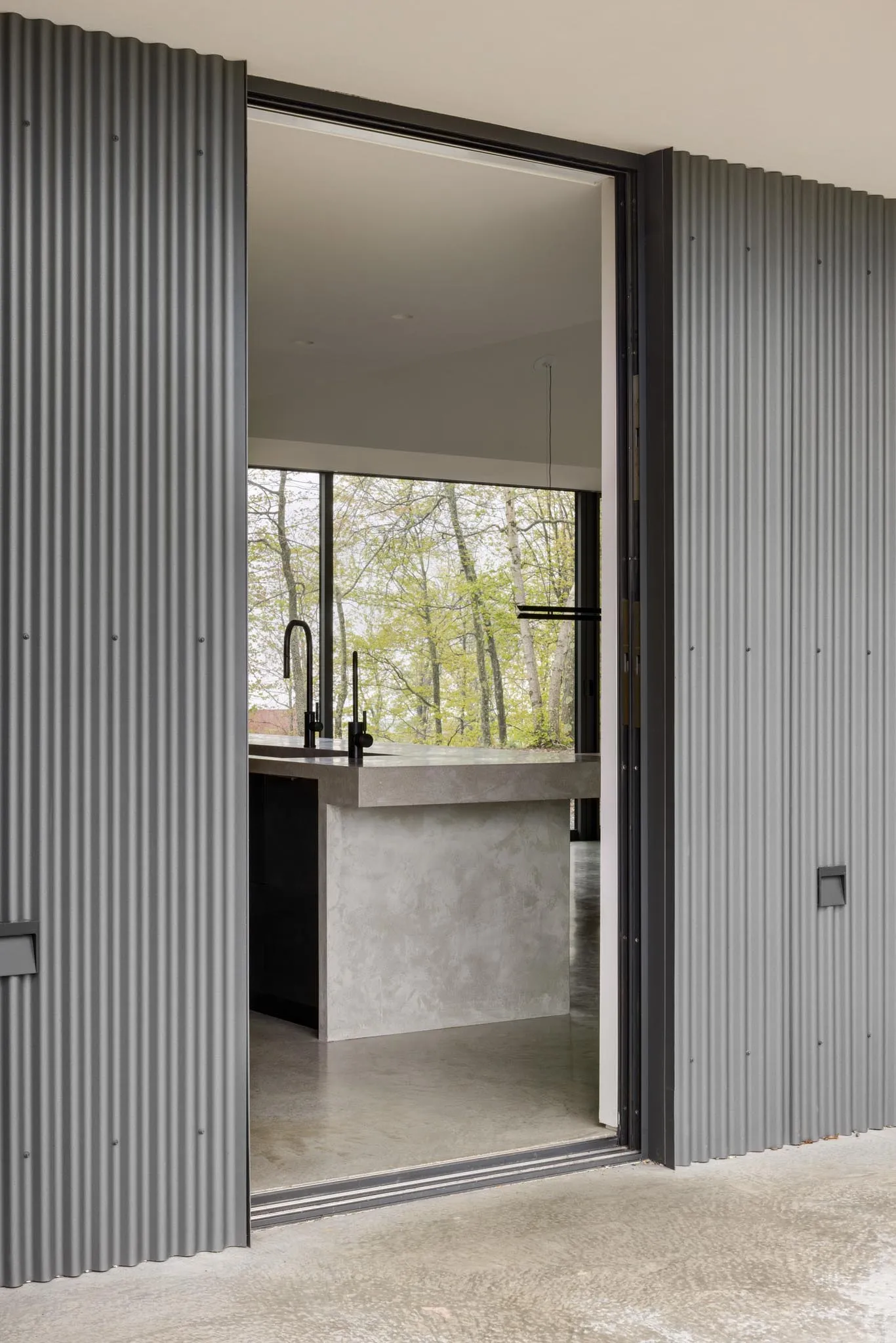 Modern minimalist kitchen with metal cabinets and concrete countertops