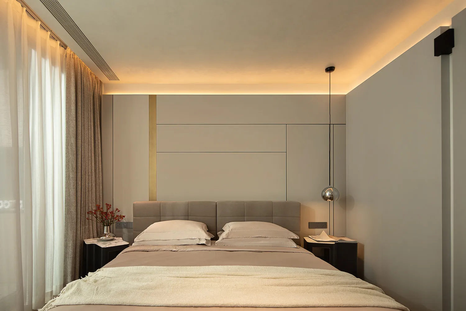 The minimalist bedroom features a bed with soft bedding on textured walls, creating a serene and inviting space.