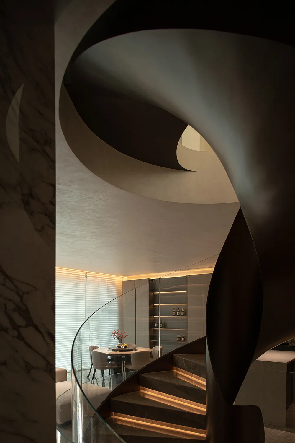 Staircase with marble steps and glass railing in a modern interior design.