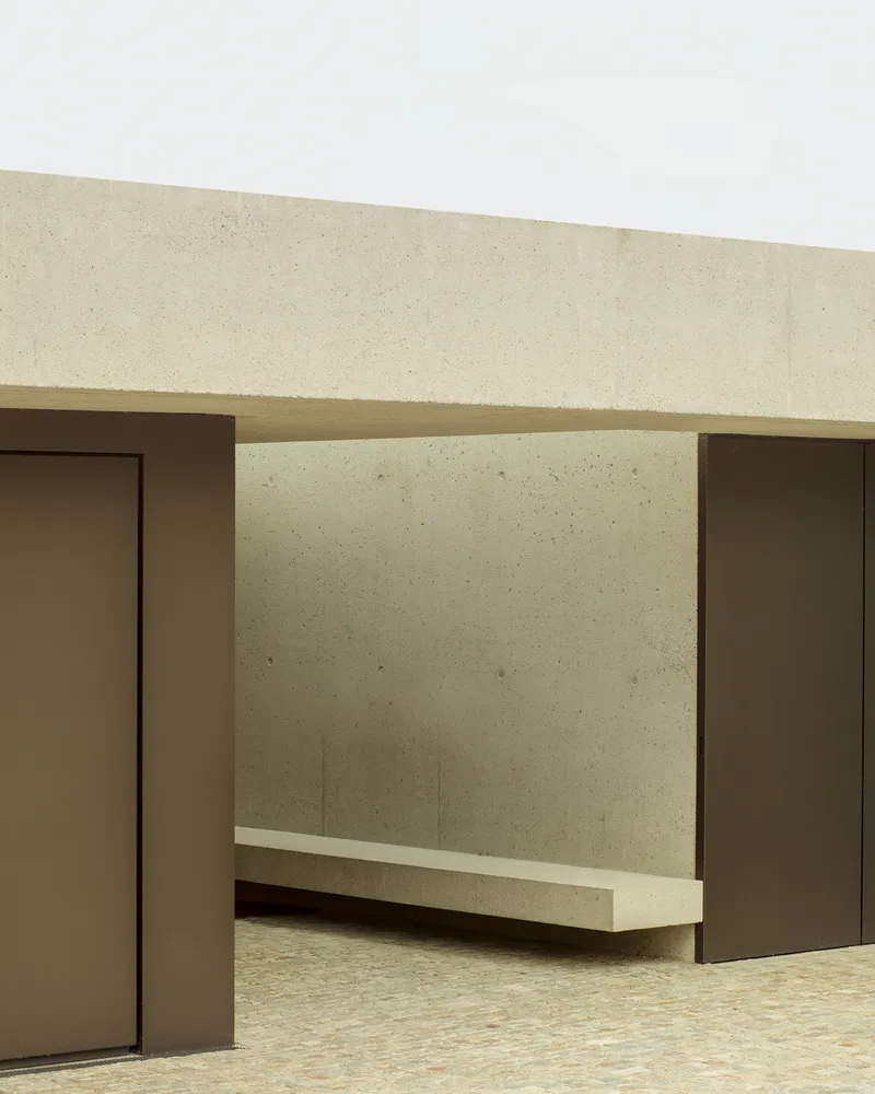 Modern, minimalist concrete bench in a serene, open-air space.