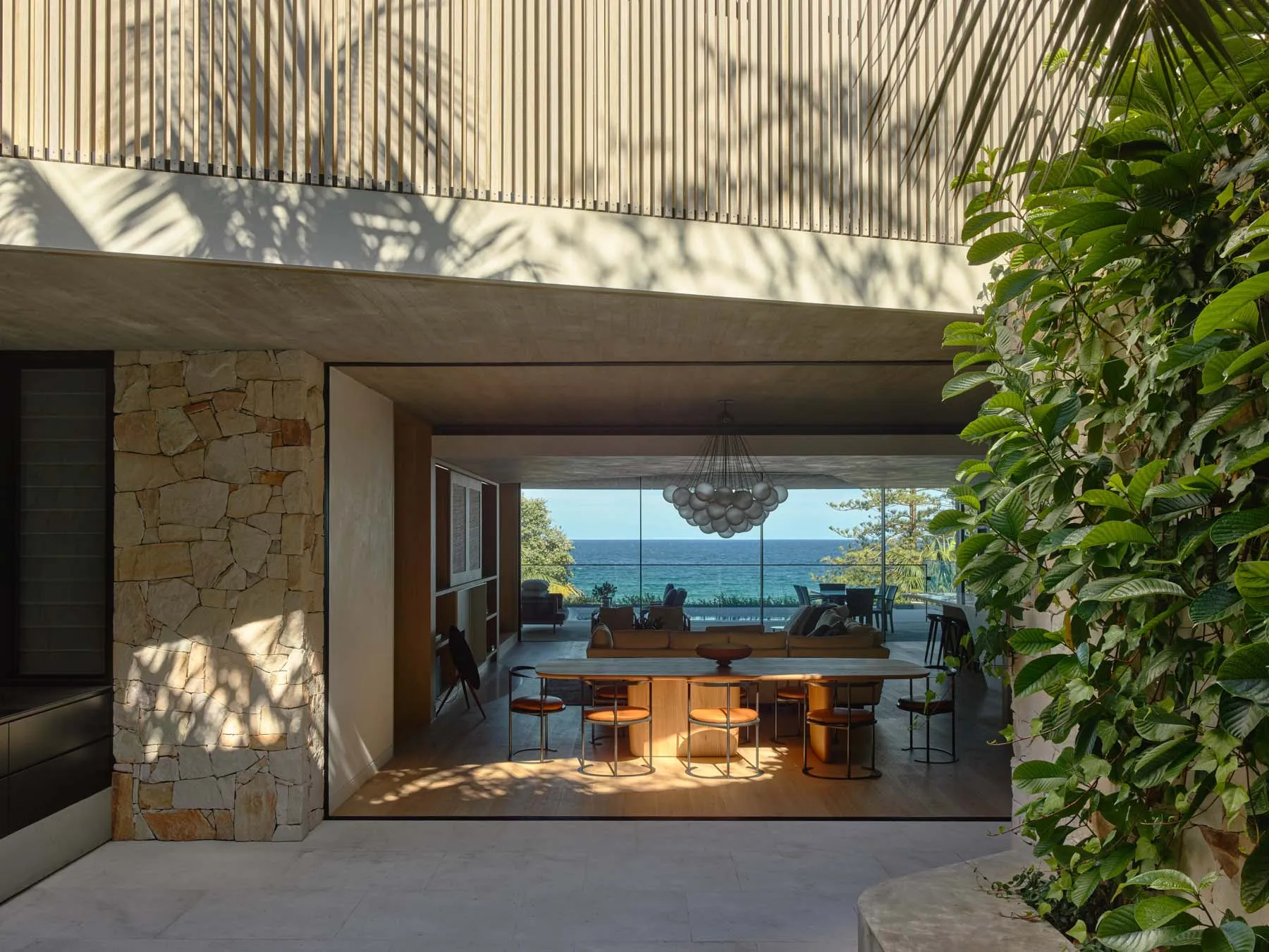 Modern minimalist living room featuring natural stone walls and wooden flooring.