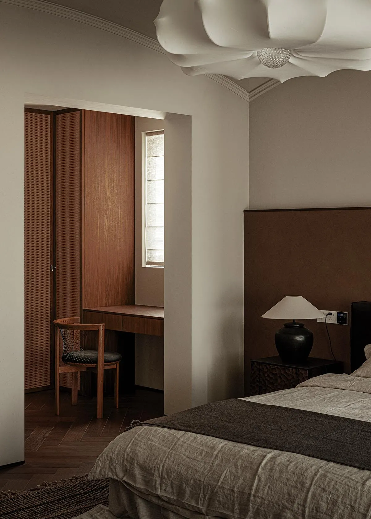 Minimalist bedroom with wooden desk, chair, and bed.