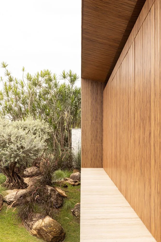A modern exterior residential garden featuring wood-grain vinyl siding.
