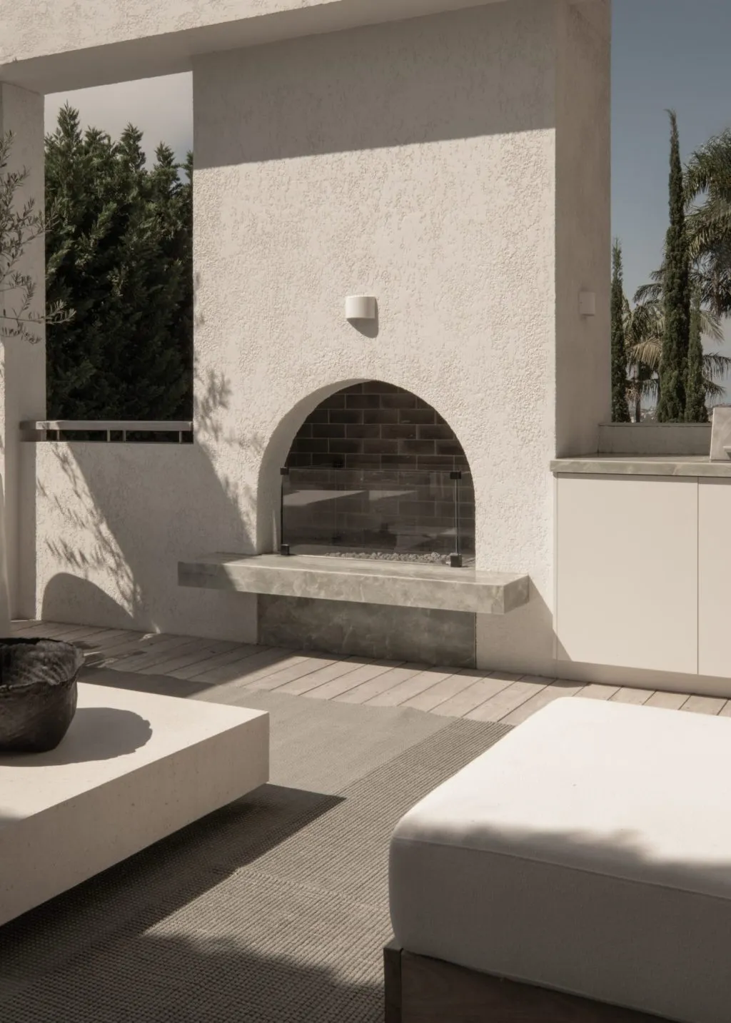 Modern outdoor patio area featuring a concrete fireplace.