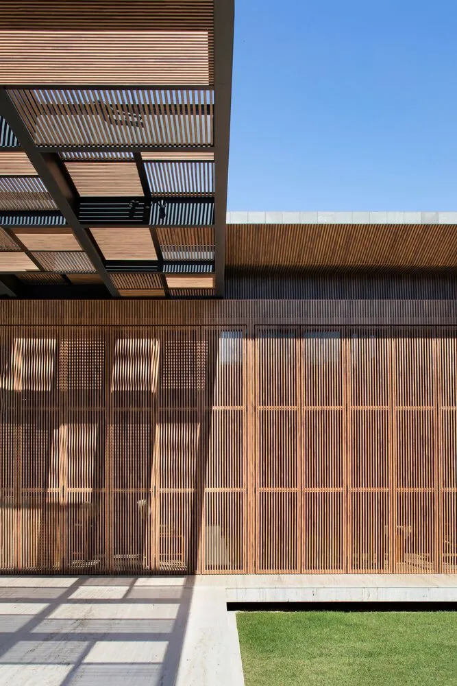 Modern architectural exterior featuring wooden slat walls and an open patio area.
