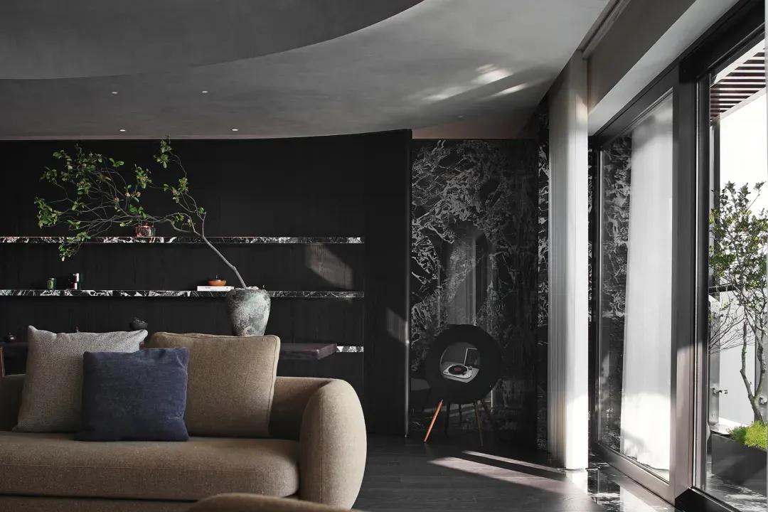 A modern living room featuring dark wood and marble elements.