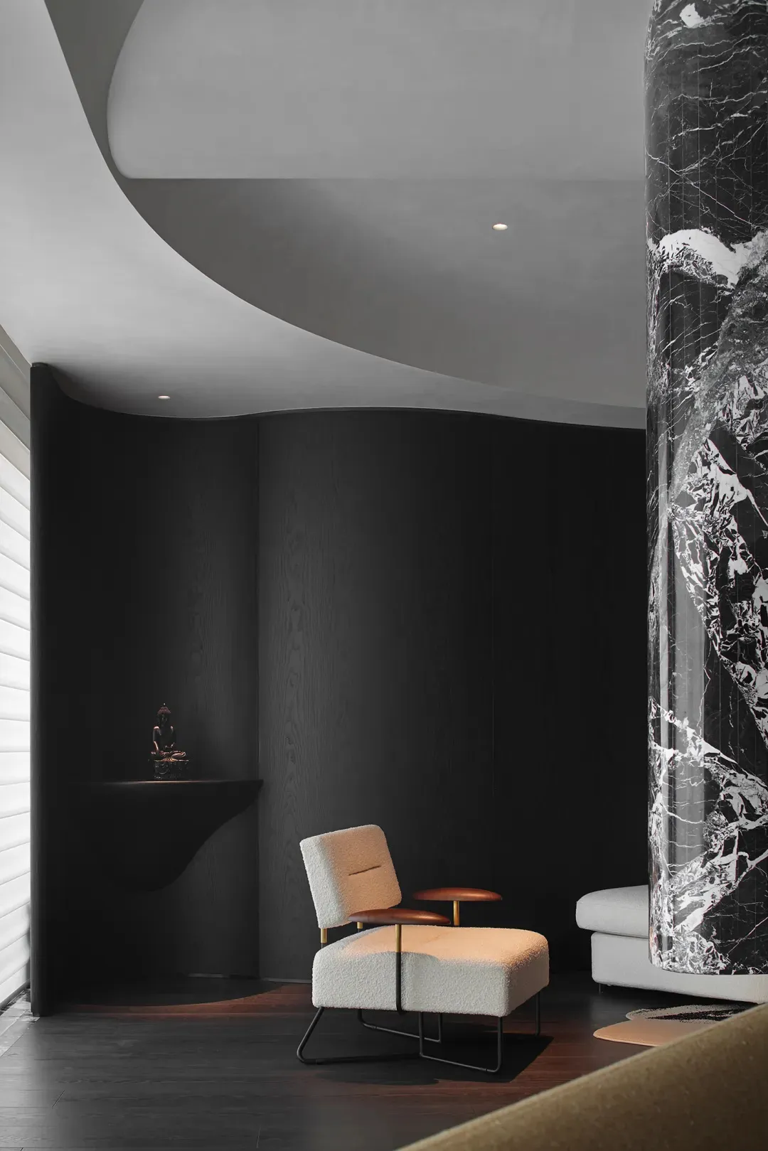 Modern living room featuring sleek marble columns and plush upholstered furniture.
