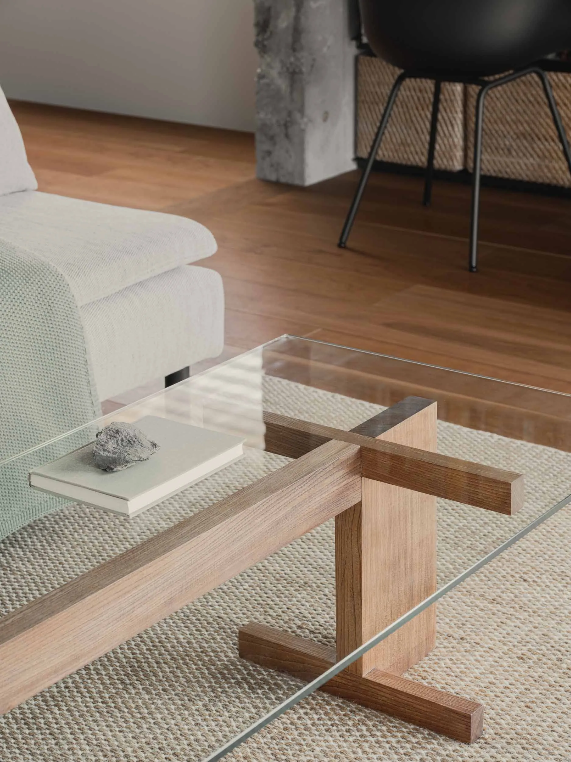 A modern living room with a glass coffee table and wooden accents.