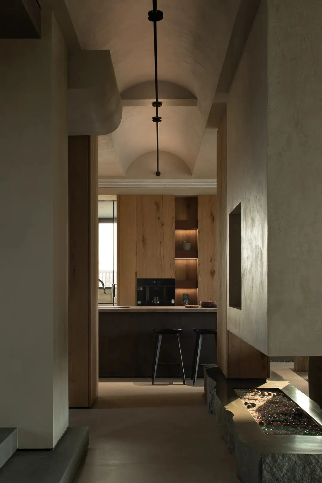 A modern residential kitchen featuring wooden finishes and minimalist design elements.