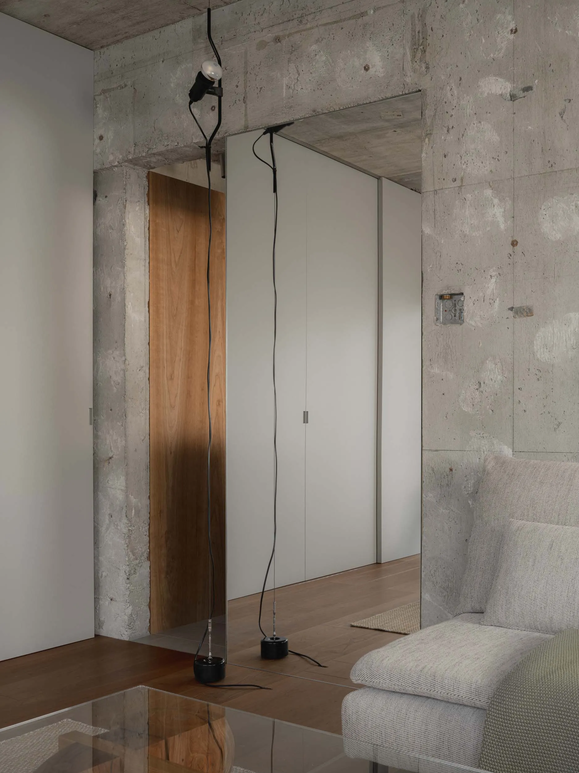 An industrial-style interior with a concrete wall and minimalist lighting.