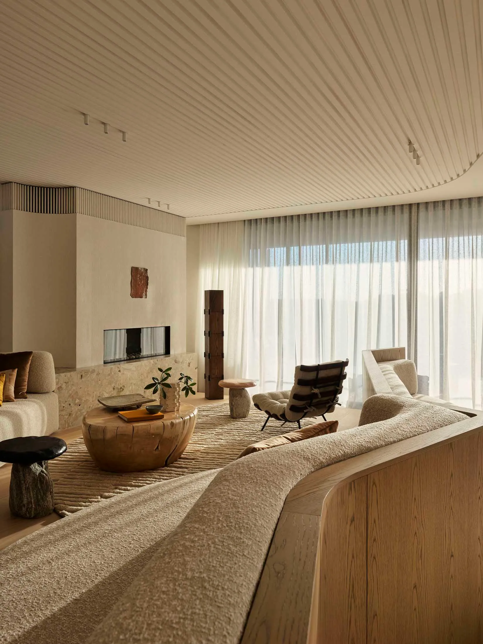 A minimalist living room with wooden furniture, fabric accents, and glass elements.