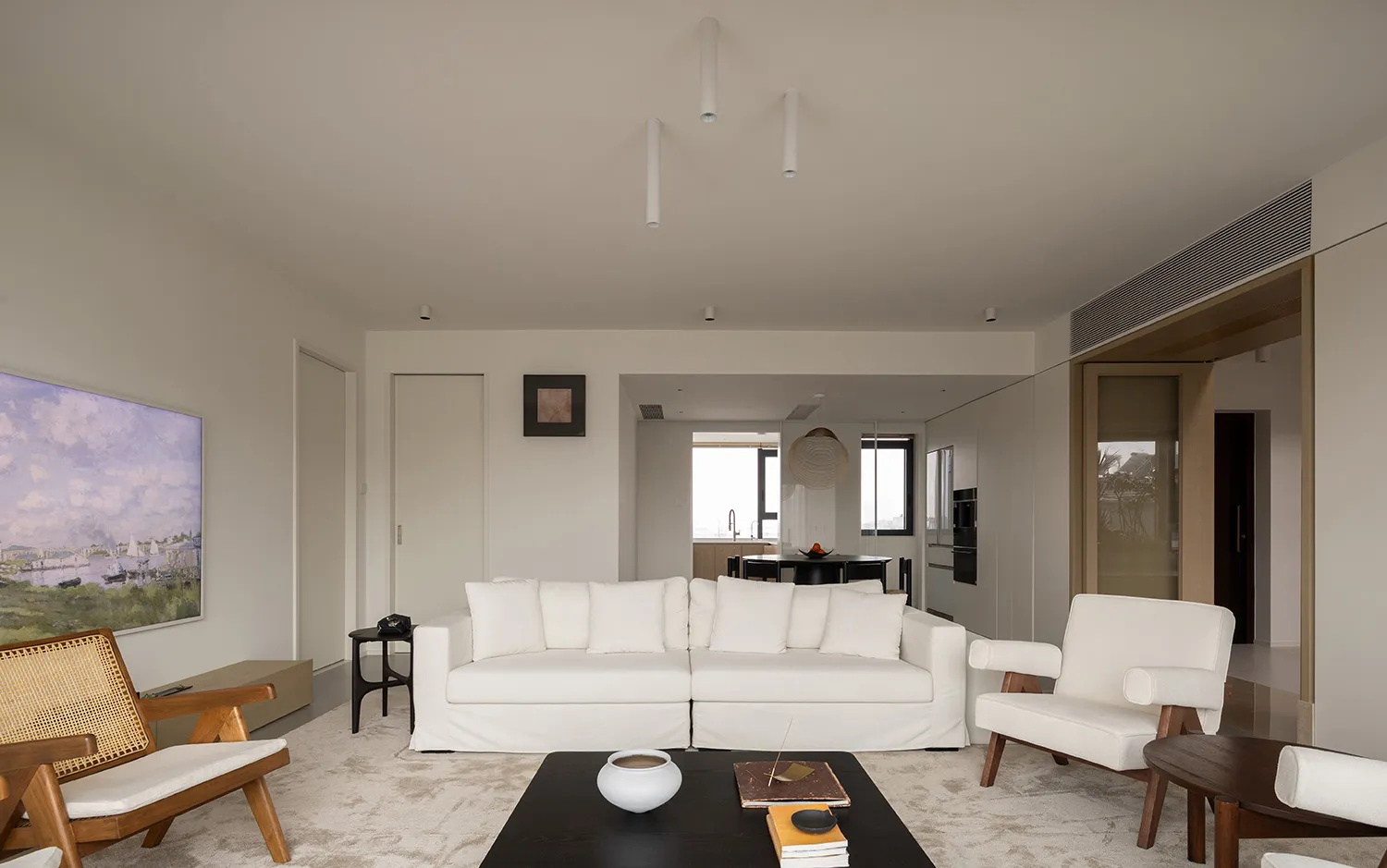 A minimalist living room with white furniture and neutral-tones decor.