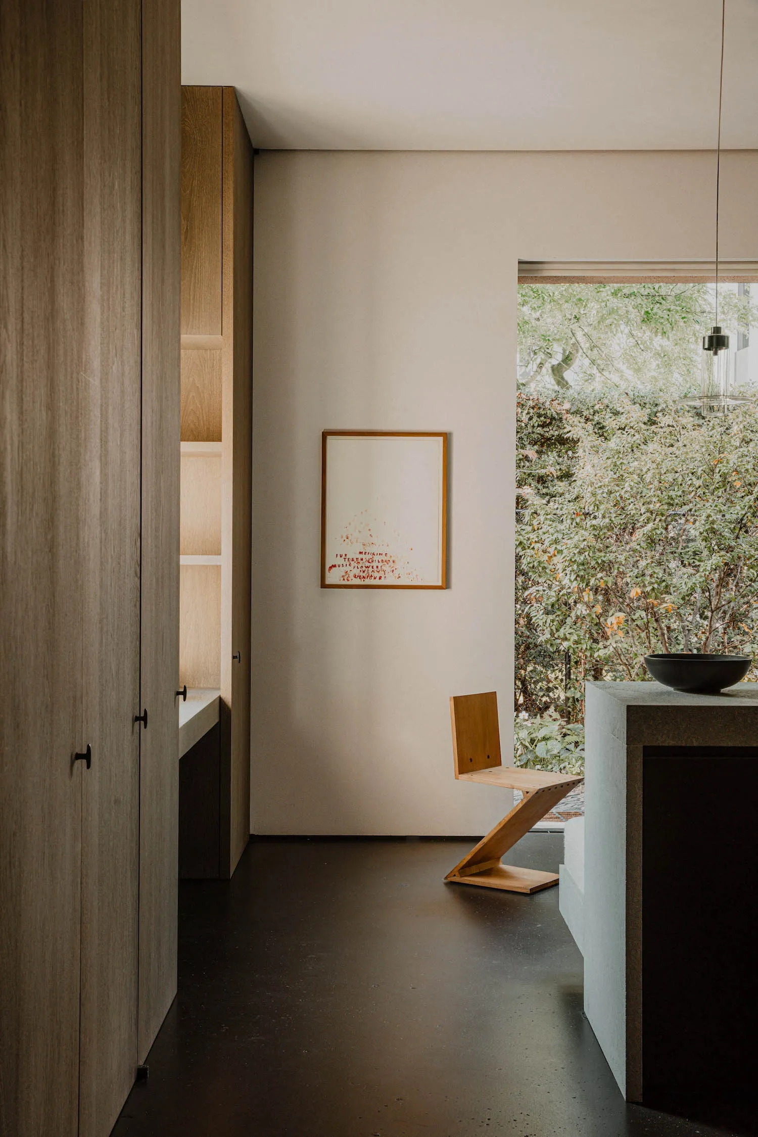A minimalist residential kitchen featuring wood and concrete materials.