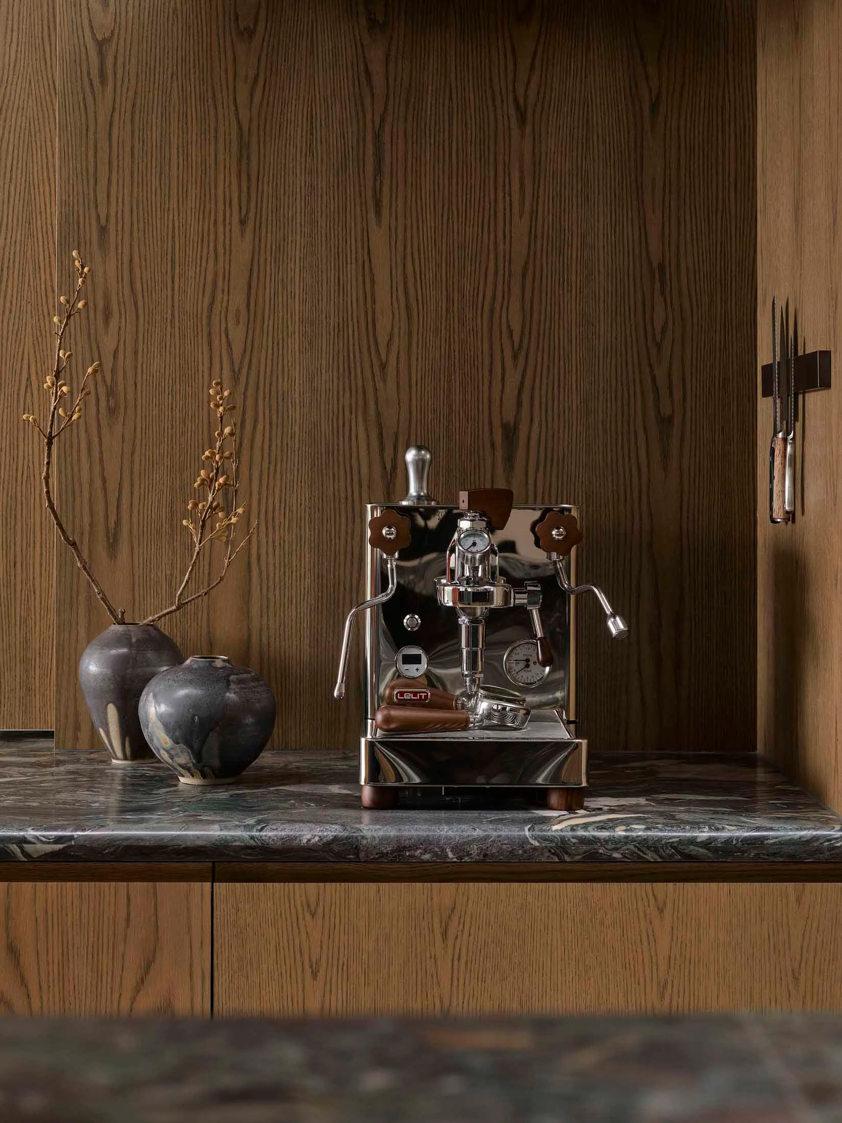 A sleek, modern kitchen featuring metallic appliances, wooden accents, and marble countertops.
