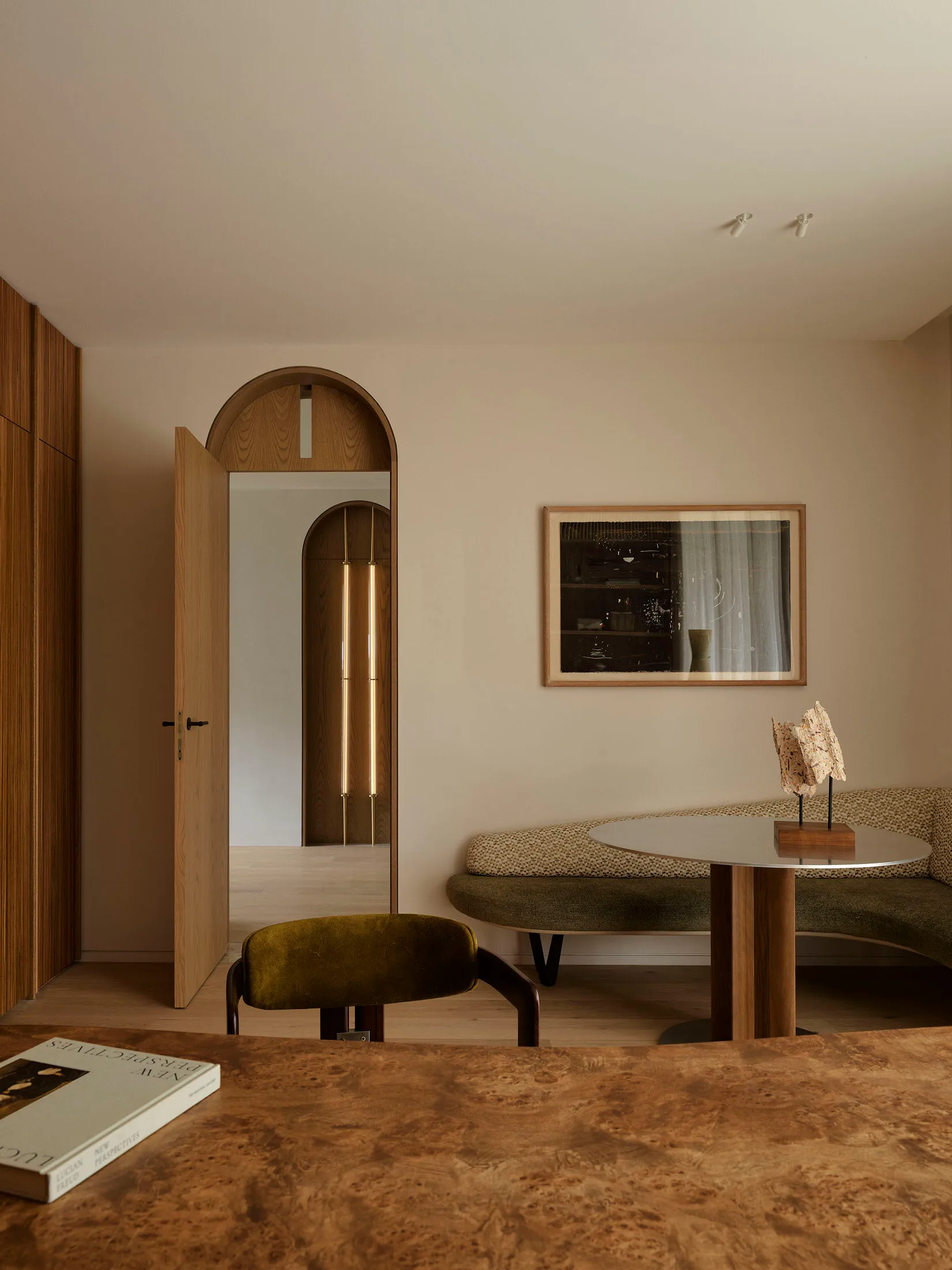 A modern living room featuring melamine veneer furniture and a round dining table with a reflective surface.