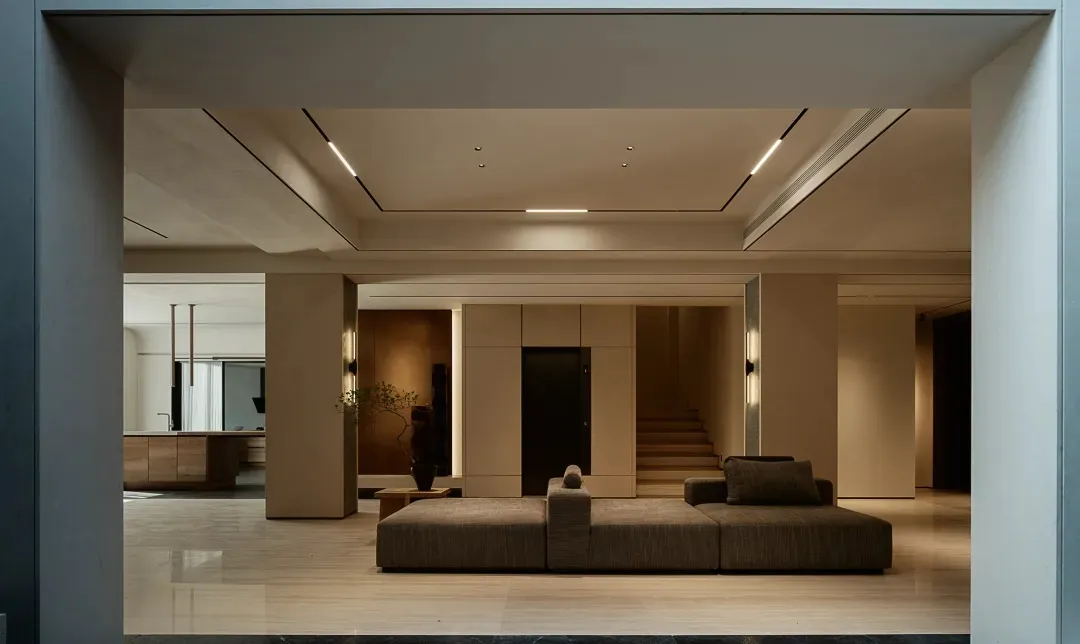 A modern, minimalist residential interior featuring sleek, metallic furniture, concrete and marble flooring, and a sophistica