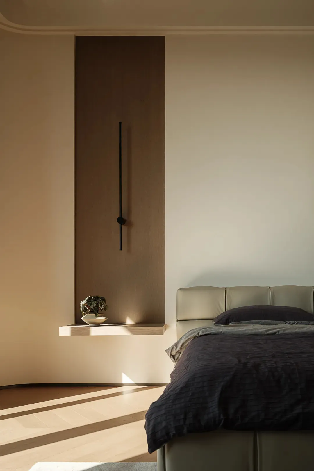A modern minimalist bedroom featuring a neutral color palette, includes a minimalist bed frame and a floating shelf with a sm