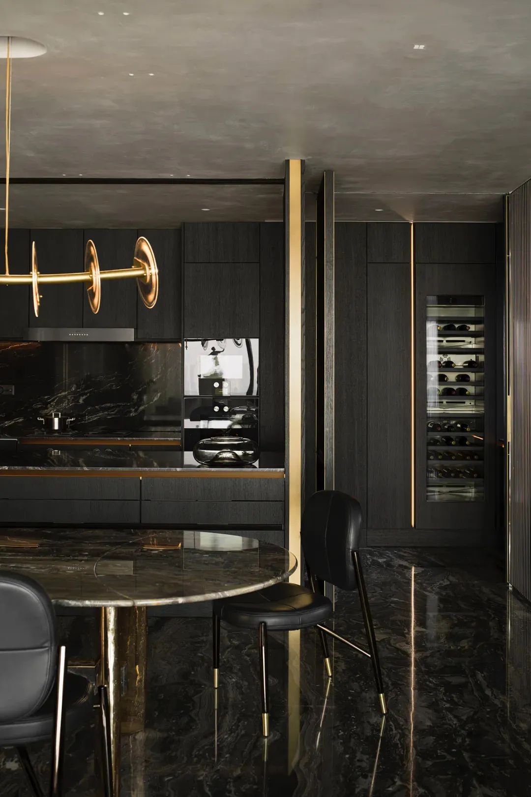 Modern luxury kitchen with black marble countertops, black and gold cabinetry, and minimalist design
