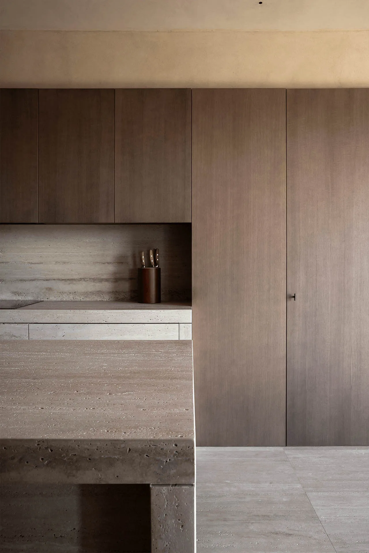 Modern, minimalist kitchen featuring concrete countertops and backsplash.
