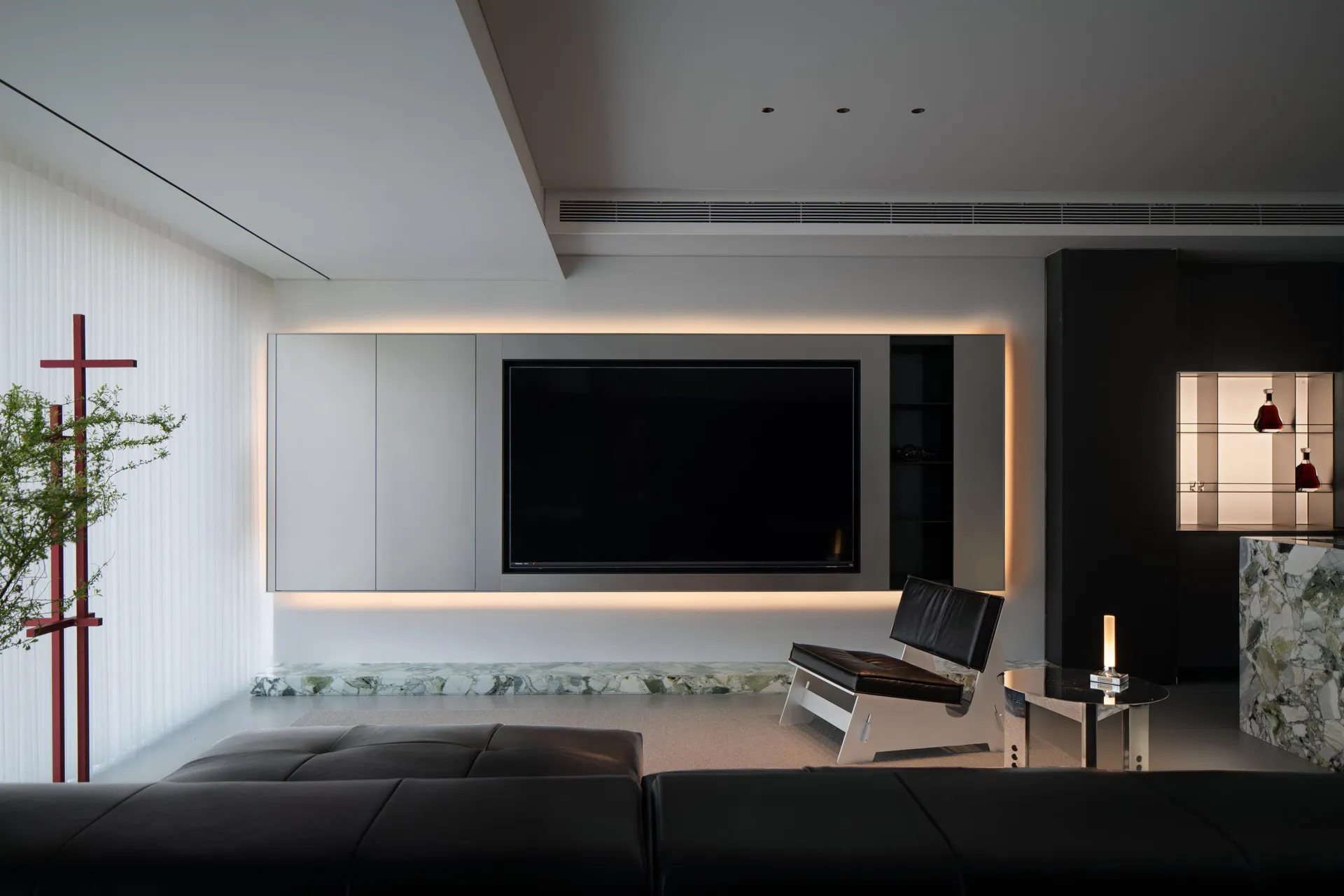 A minimalist living room featuring white marble floors and black steel furniture.