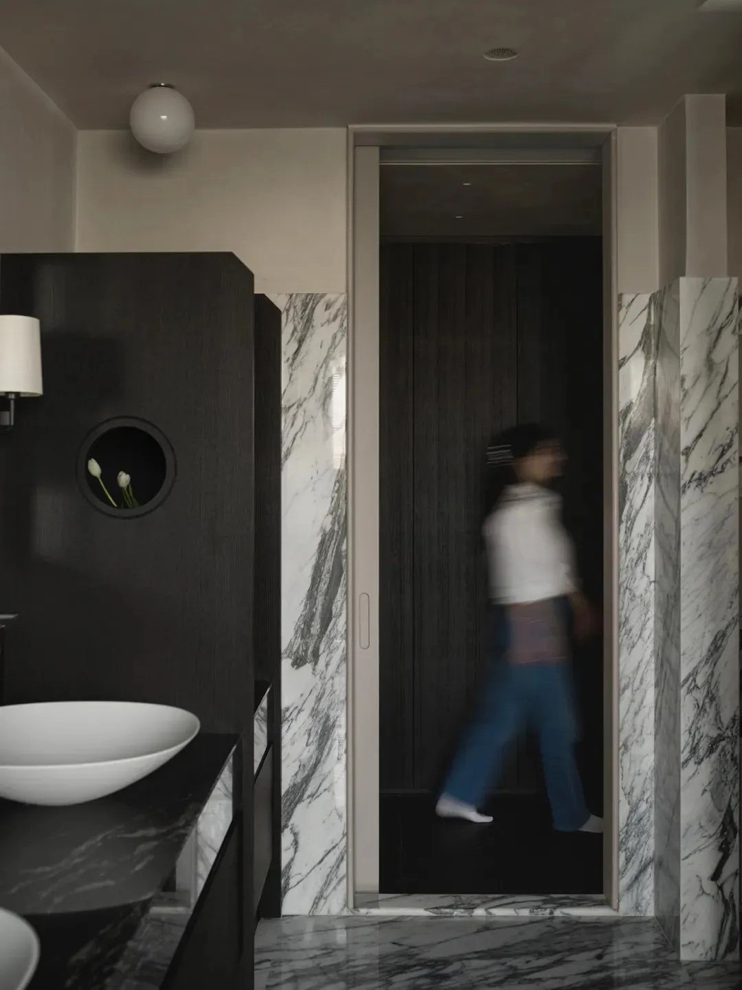 A modern bathroom with marble walls and wooden elements