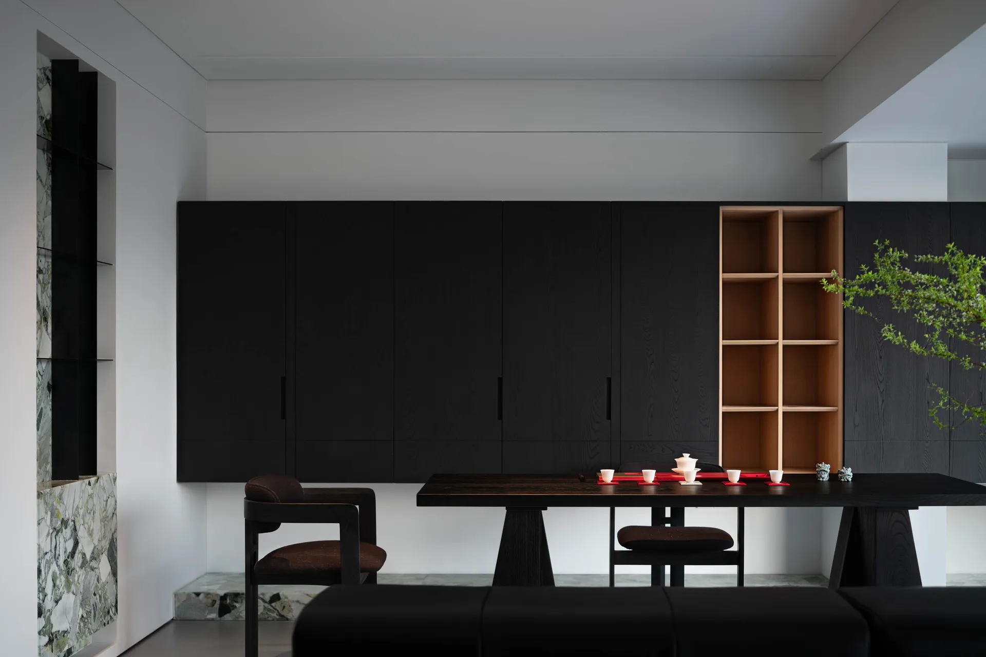 A modern black interior design featuring black wooden furniture and a black marble tabletop.