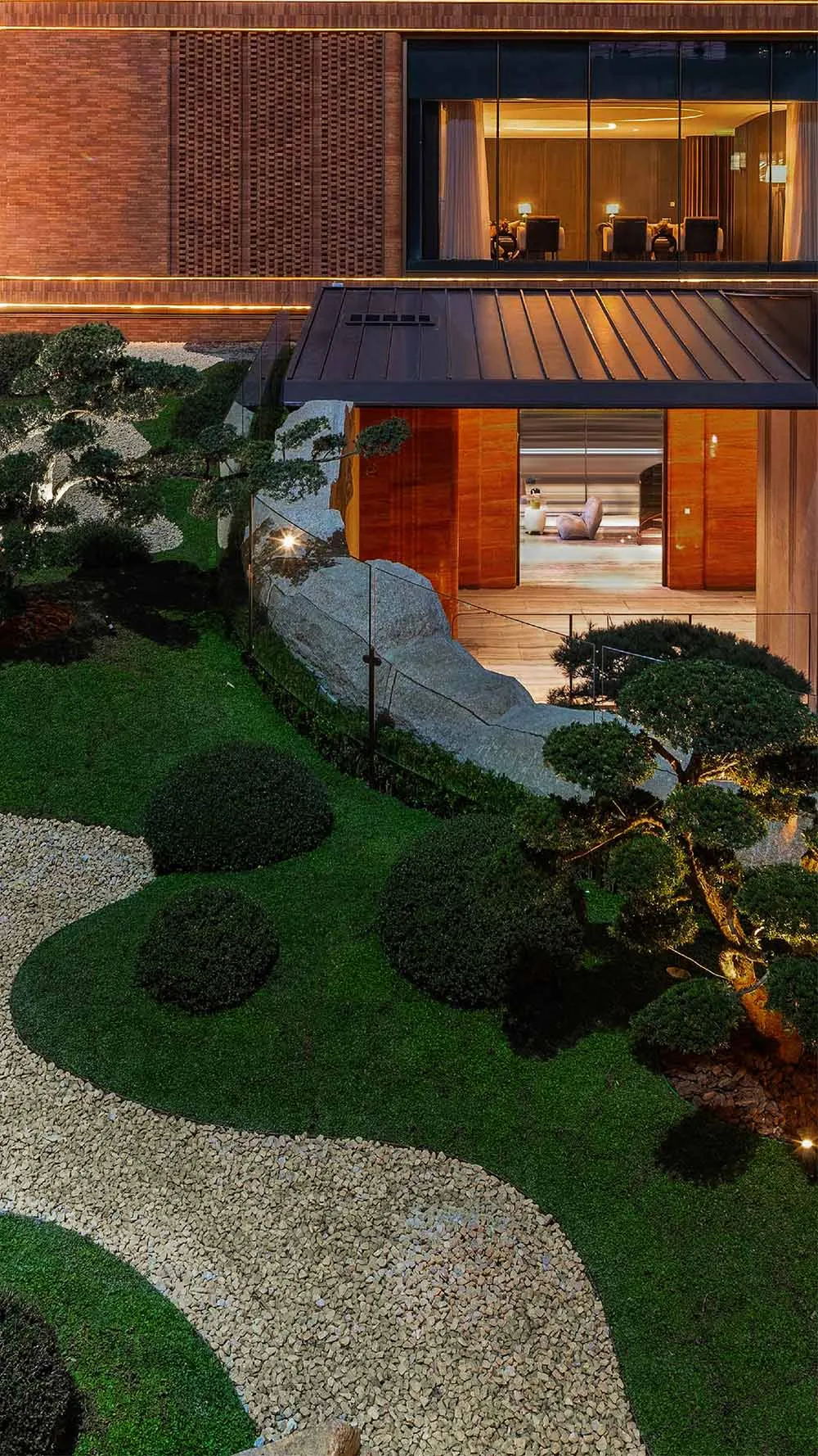 現代花園景觀,搭配天然石材、礫石步道與茂密綠意,設有混凝土步道。