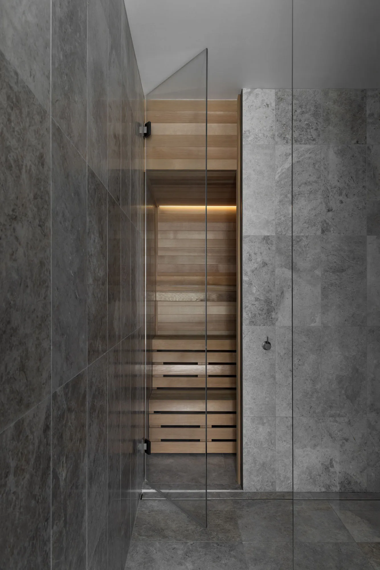 Modern marble bathroom with industrial lighting and minimalist design.
