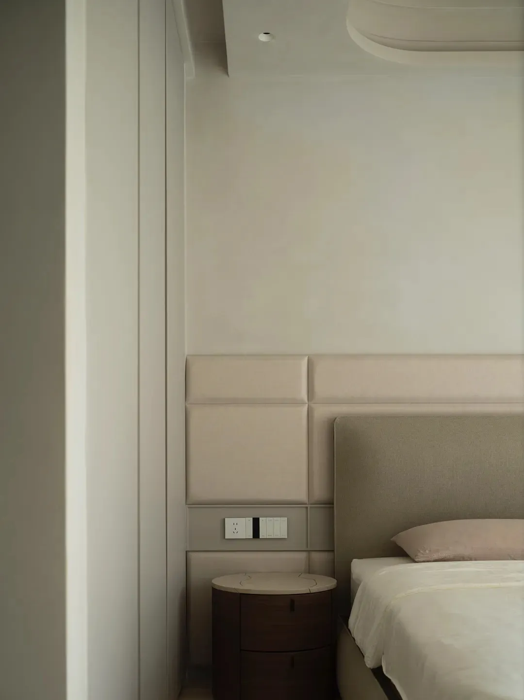 Modern minimalist bedroom showcasing wall paneling and floor plan details.