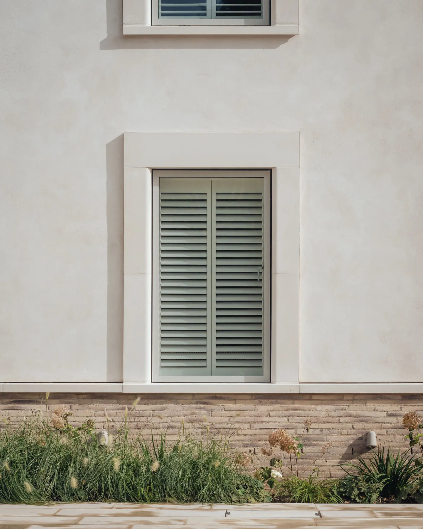 Window with white primative stucco and brick material